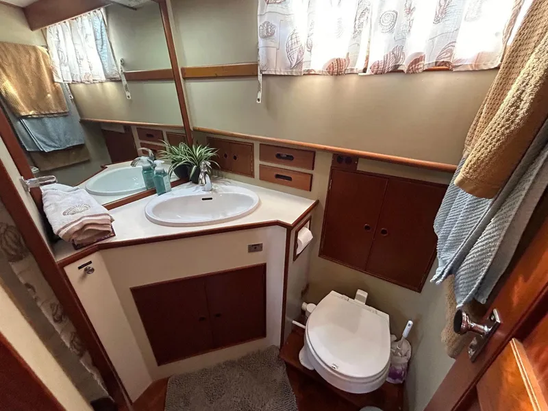 Slide: The Image of 1986 Grand Banks 42 Classic yacht bathroom with sink, toilet, and storage cabinets. - 41