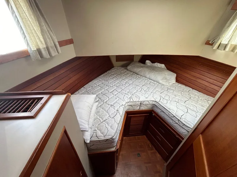 Slide: The Image of 1986 Grand Banks 42 Classic cabin with wooden interior and cozy bed. - 43