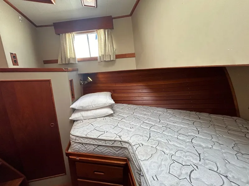 Slide: The Image of Cozy cabin interior of 1986 Grand Banks 42 Classic yacht with wooden paneling and bed. - 46