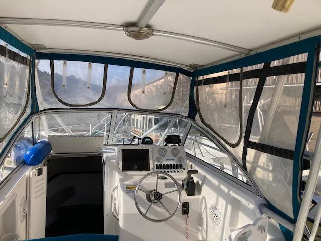 Slide: The Image of 2002 Sea Pro 235 Walk Around boat interior with steering wheel and navigation equipment. - 10