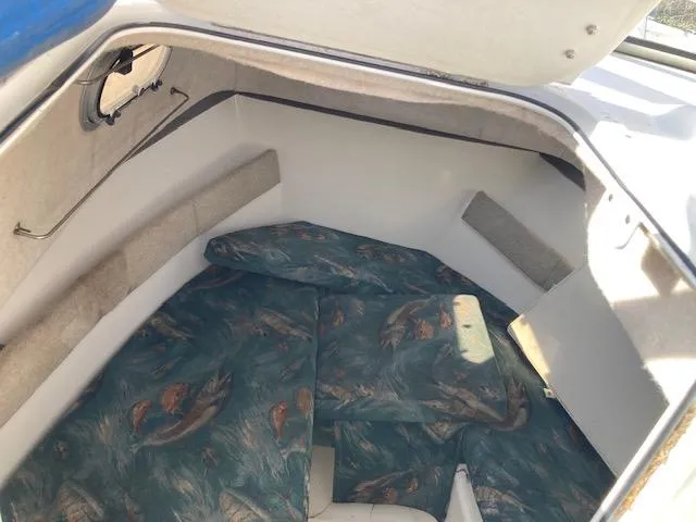 Slide: The Image of 2002 Sea Pro 235 Walk Around cabin interior with patterned cushions. - 12