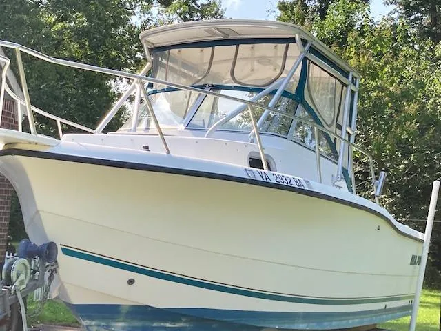 The Image of 2002 Sea Pro 235 Walk Around boat, white hull, docked outdoors. - 2