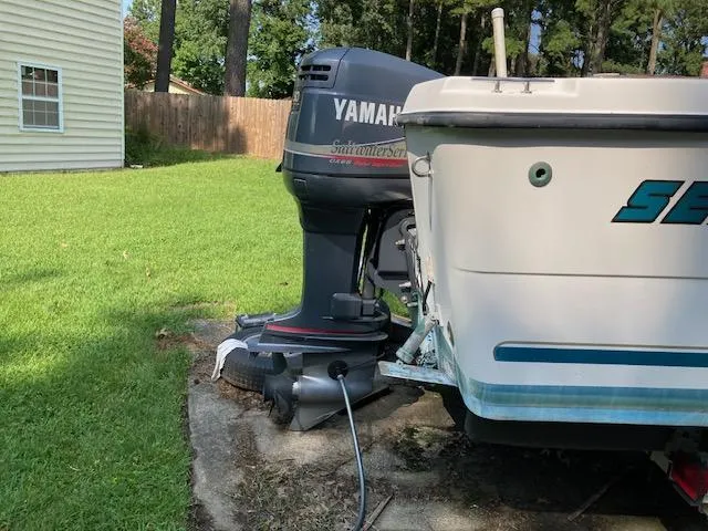 Slide: The Image of 2002 Sea Pro 235 Walk Around boat with Yamaha outboard motor in a backyard setting. - 7