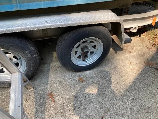 Slide: The Image of Trailer wheels of a 2002 Sea Pro 235 Walk Around boat on concrete. - 9