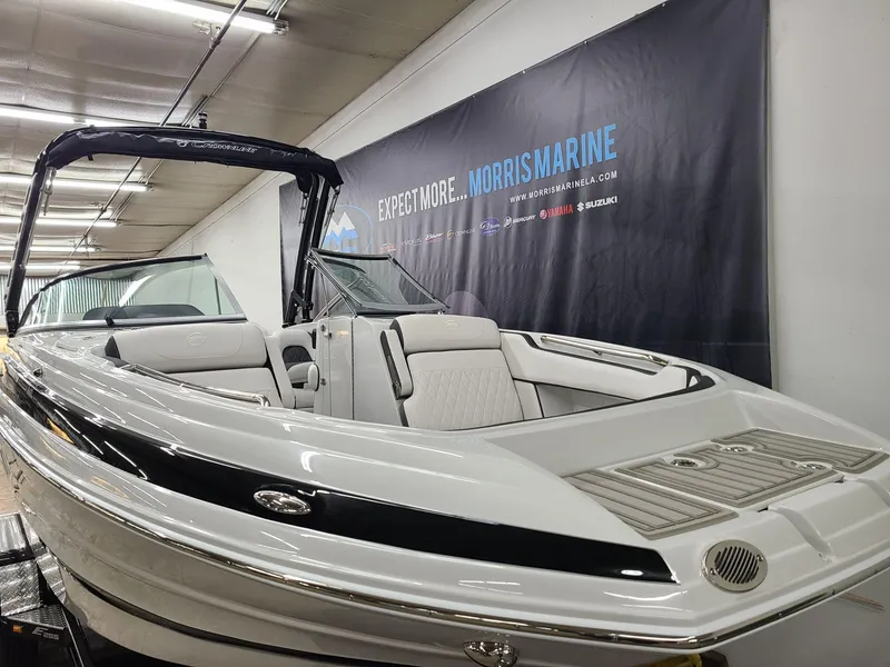 Slide: The Image of 2024 Crownline Eclipse E255 SURF boat in showroom, sleek design, luxury seating. - 3