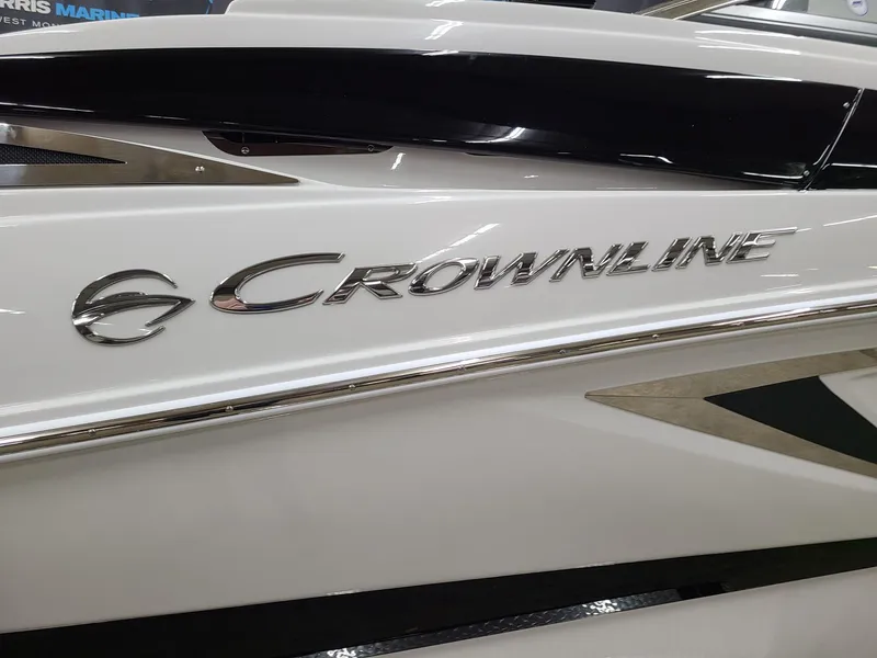 Slide: The Image of 2024 Crownline Eclipse E255 SURF boat, sleek white exterior with logo detail. - 4