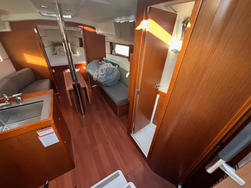 Slide: The Image of Interior of 2019 Beneteau Oceanis 35.1 sailboat with wood finish and cozy seating. - 14