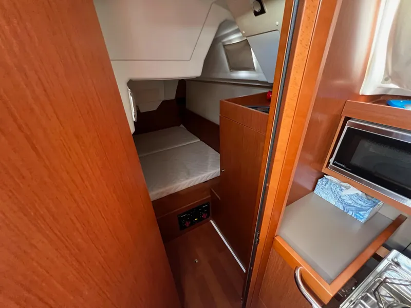 Slide: The Image of Interior cabin of 2019 Beneteau Oceanis 35.1 sailboat with wood finish and compact amenities. - 22