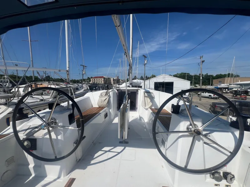 Slide: The Image of 2019 Beneteau Oceanis 35.1 sailboat cockpit with dual steering wheels, docked under clear skies. - 4