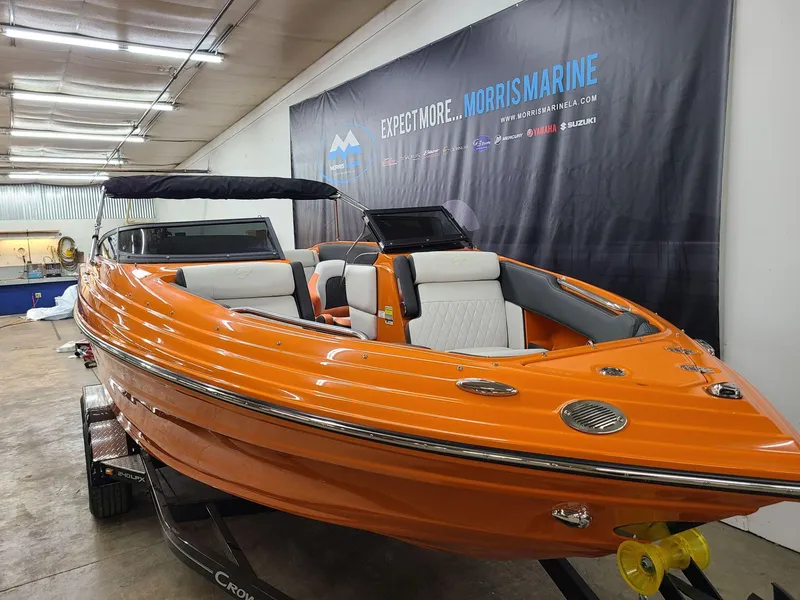 Slide: The Image of 2024 Crownline 240 SS LPX boat in vibrant orange, displayed indoors. - 7