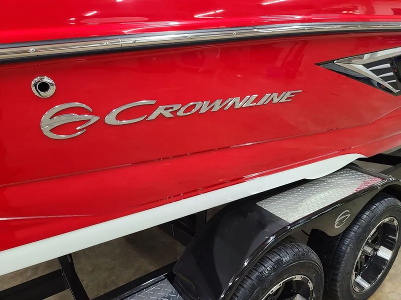 Slide: The Image of Red 2024 Crownline 240 SS SURF boat on trailer, showcasing sleek design and logo. - 3