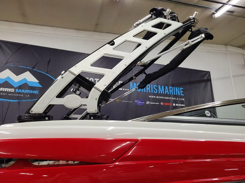 Slide: The Image of 2024 Crownline 240 SS SURF boat with sleek red and white design, showcased indoors. - 6