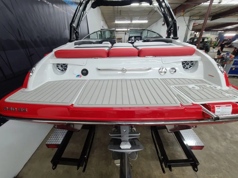 Slide: The Image of 2024 Crownline 240 SS SURF boat, rear view with red and white seating, in showroom. - 8