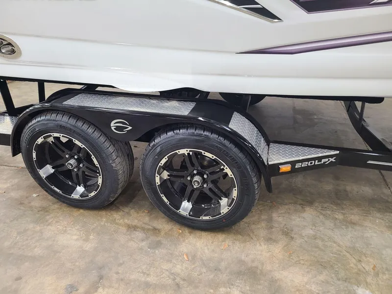 Slide: The Image of 2024 Crownline 220 SS LPX boat trailer with dual black alloy wheels. - 7