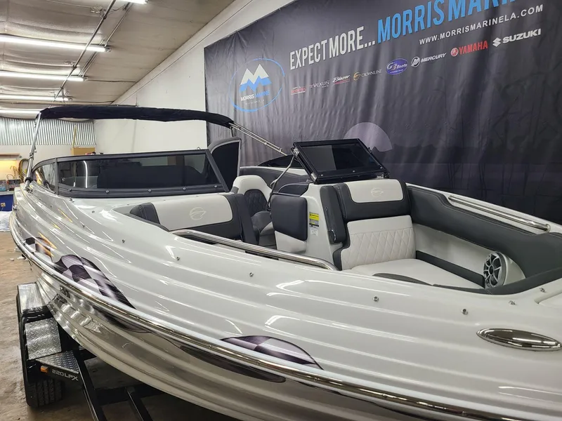 Slide: The Image of 2024 Crownline 220 SS LPX boat in showroom, sleek design, white and gray interior. - 8