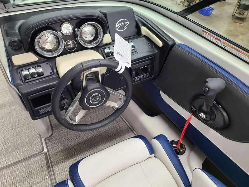 Slide: The Image of 2024 Crownline 210 SS boat dashboard with steering wheel and control panel. - 11