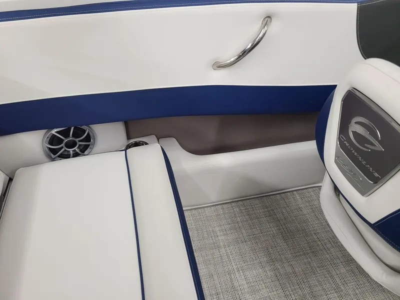 Slide: The Image of 2024 Crownline 210 SS interior with blue and white seating, speaker, and handle. - 13
