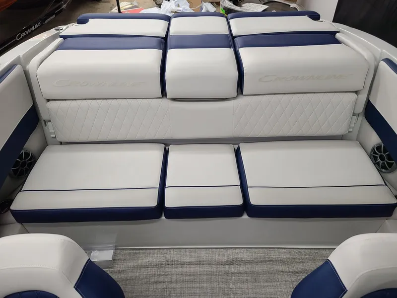 Slide: The Image of 2024 Crownline 210 SS boat interior with white and blue cushioned seating. - 14