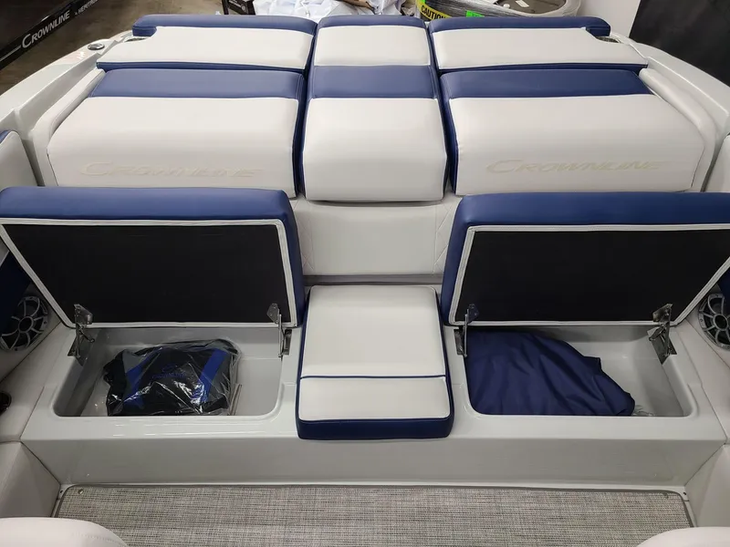 Slide: The Image of 2024 Crownline 210 SS boat interior with blue and white seating and storage compartments. - 15