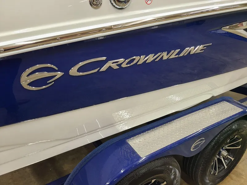 Slide: The Image of 2024 Crownline 210 SS boat with blue and white exterior on trailer. - 4