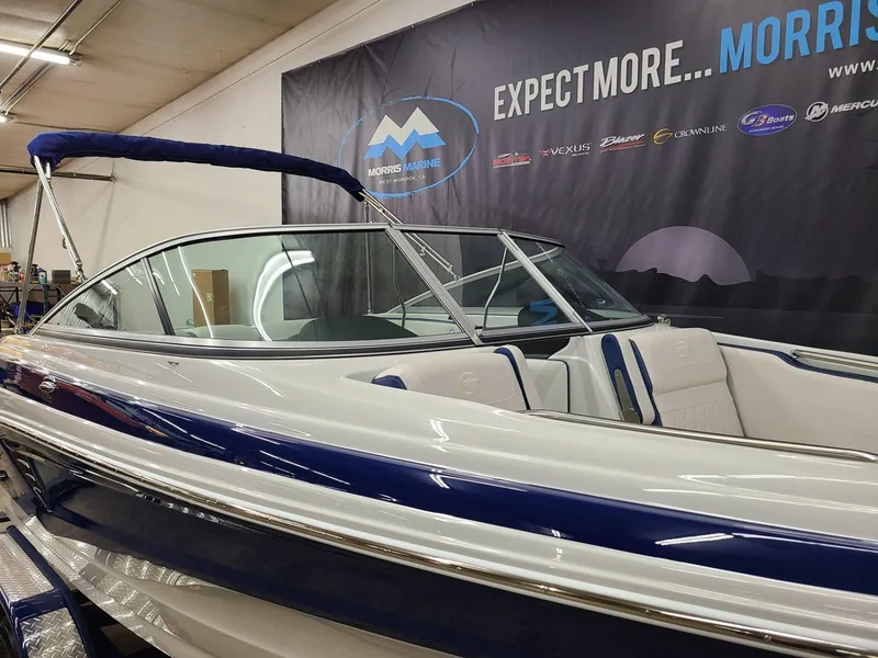 Slide: The Image of 2024 Crownline 210 SS boat in showroom, featuring sleek design and blue accents. - 6