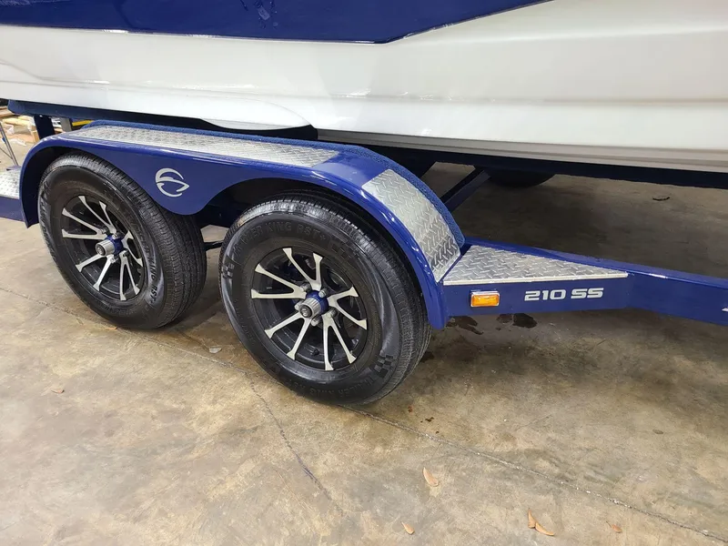Slide: The Image of 2024 Crownline 210 SS boat trailer with dual wheels on a concrete floor. - 7