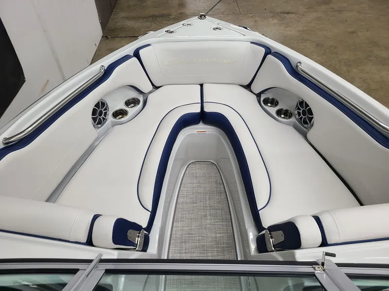 Slide: The Image of 2024 Crownline 210 SS boat interior with white and blue seating, cup holders, and speakers. - 9