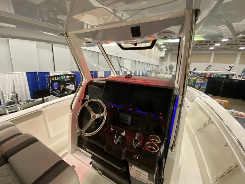 Slide: The Image of 2024 Pursuit S 358 boat helm with modern controls and steering wheel at a boat show. - 11