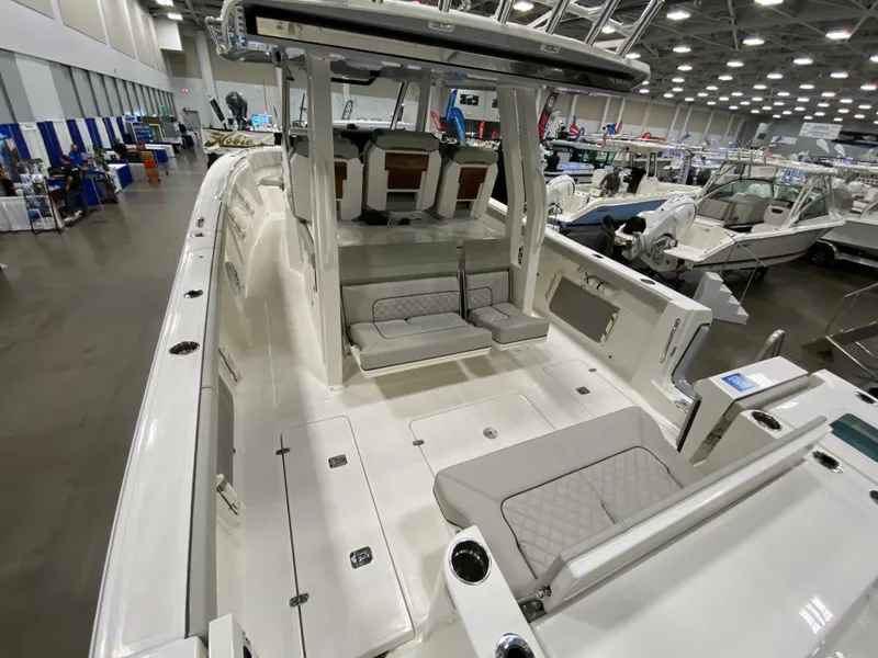Slide: The Image of 2024 Pursuit S 358 boat interior at a boat show, featuring spacious seating and modern design. - 7