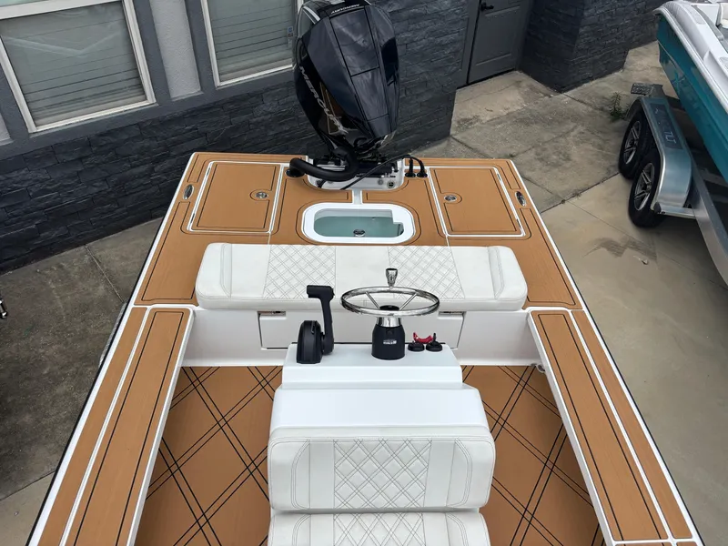 Slide: The Image of 2024 Vtech 18 FLATS boat interior with tan and white seating, steering wheel, and motor. - 13
