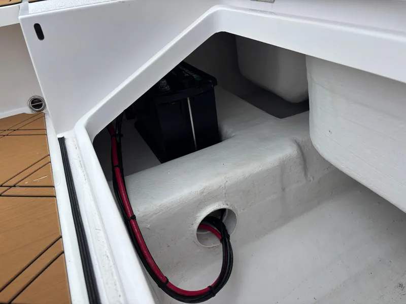 Slide: The Image of 2024 Vtech 18 FLATS boat battery compartment with visible wiring and storage space. - 18