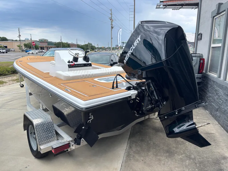 Slide: The Image of 2024 Vtech 18 FLATS boat with Mercury engine on trailer, parked outdoors. - 2