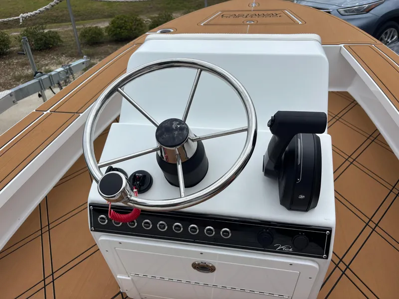 Slide: The Image of 2024 Vtech 18 FLATS boat steering console with modern controls and wooden deck. - 21