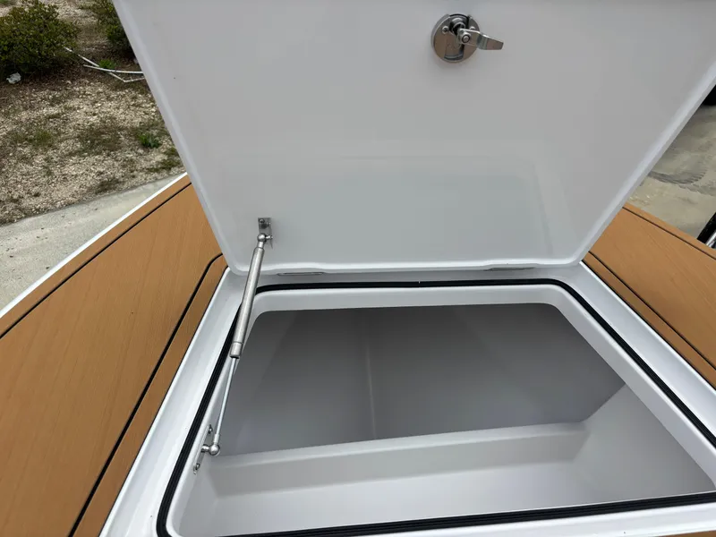 Slide: The Image of Open storage compartment on 2024 Vtech 18 FLATS boat, featuring a secure latch. - 33