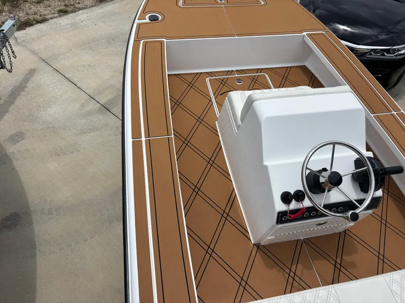 Slide: The Image of 2024 Vtech 18 FLATS boat with brown deck and white console, featuring a steering wheel. - 7