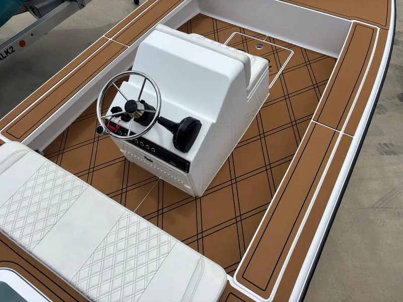 Slide: The Image of 2024 Vtech 18 FLATS boat interior with brown deck and white seating. - 8