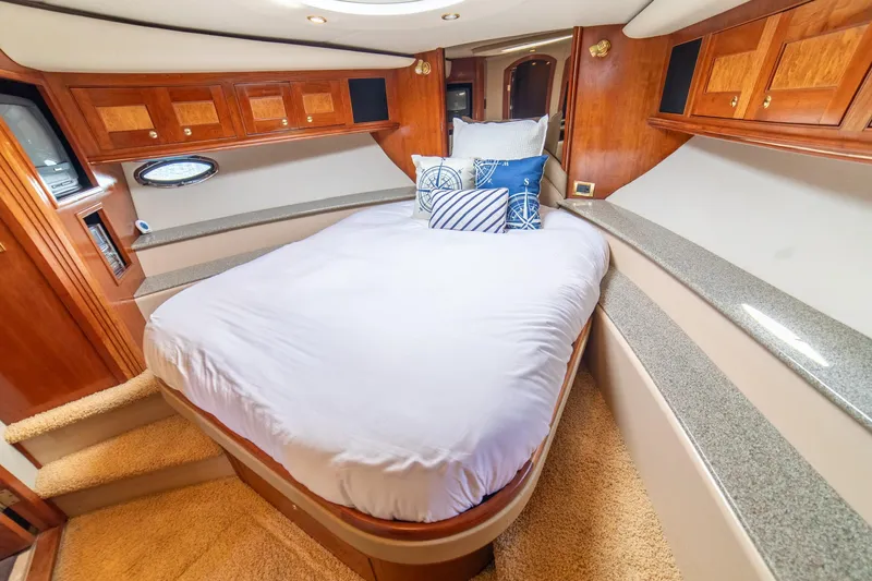 Slide: The Image of Luxurious 2002 Cruisers Yachts 5370 Express cabin with cozy bed and elegant wood finish. - 20