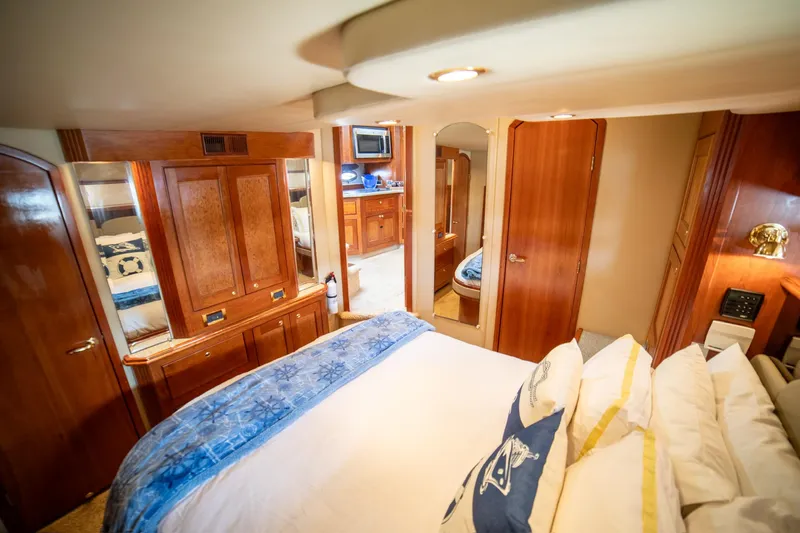 Slide: The Image of Luxurious 2002 Cruisers Yachts 5370 Express cabin interior with wood finishes and cozy bedding. - 22