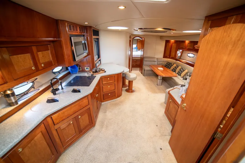 Slide: The Image of Luxurious interior of 2002 Cruisers Yachts 5370 Express with wood cabinetry and seating area. - 23