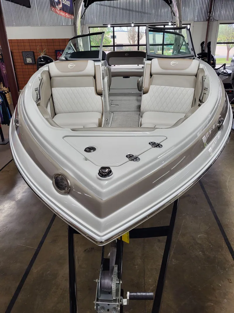 Slide: The Image of 2023 Crownline 260 SS boat with luxurious seating in showroom. - 6