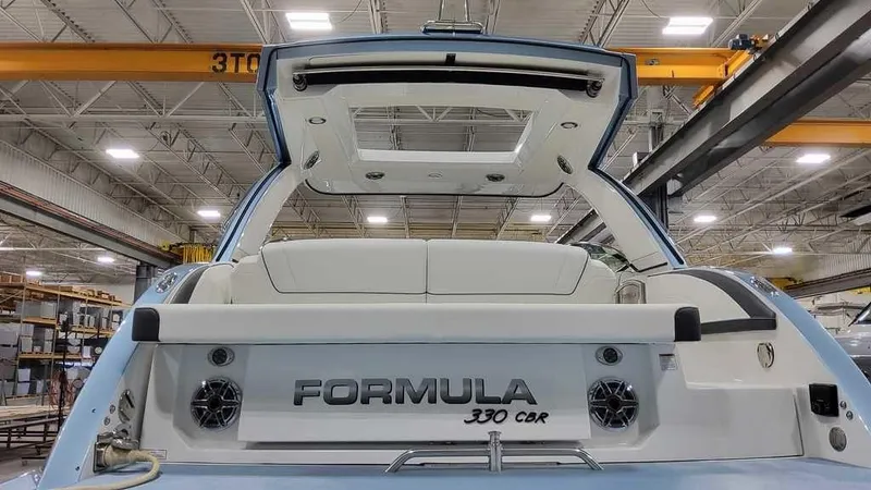 Slide: The Image of 2025 Formula 330 Crossover Bowrider in a factory setting, showcasing rear design and seating. - 10