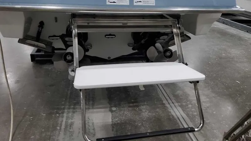 Slide: The Image of 2025 Formula 330 Crossover Bowrider swim platform with ladder in a garage setting. - 12