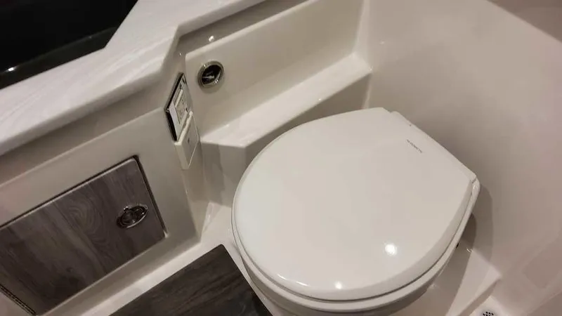 Slide: The Image of 2025 Formula 330 Crossover Bowrider bathroom with modern toilet and storage cabinet. - 30