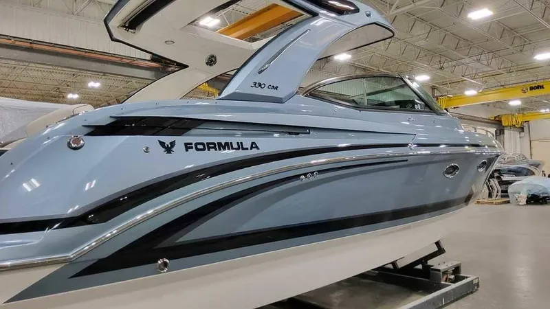 Slide: The Image of 2025 Formula 330 Crossover Bowrider boat in a showroom, sleek design and modern features. - 5