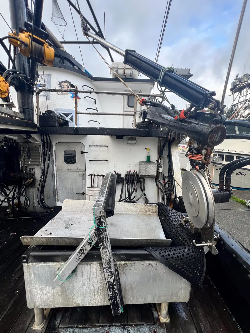 Slide: The Image of 1980 custom fishing vessel deck with equipment and machinery, overcast sky in background. - 12