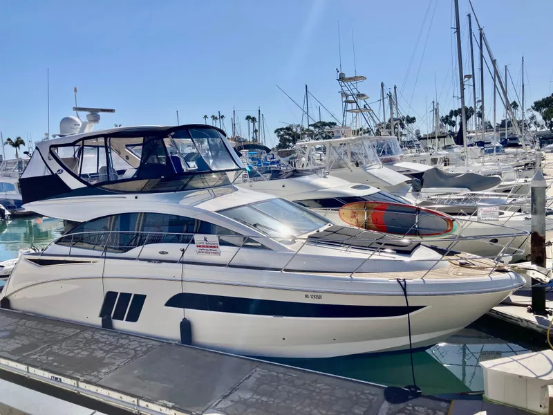Slide: The Image of 2018 Sea Ray Fly 510 yacht docked at marina, sunny day. - 0