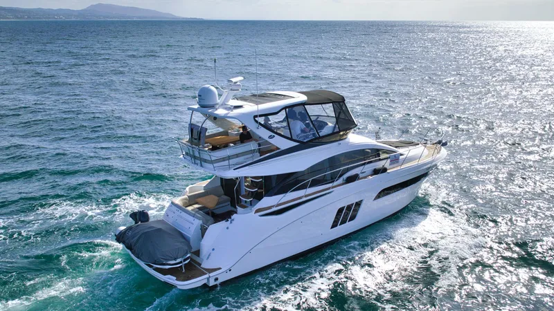 Slide: The Image of 2018 Sea Ray Fly 510 yacht cruising on open water. - 10