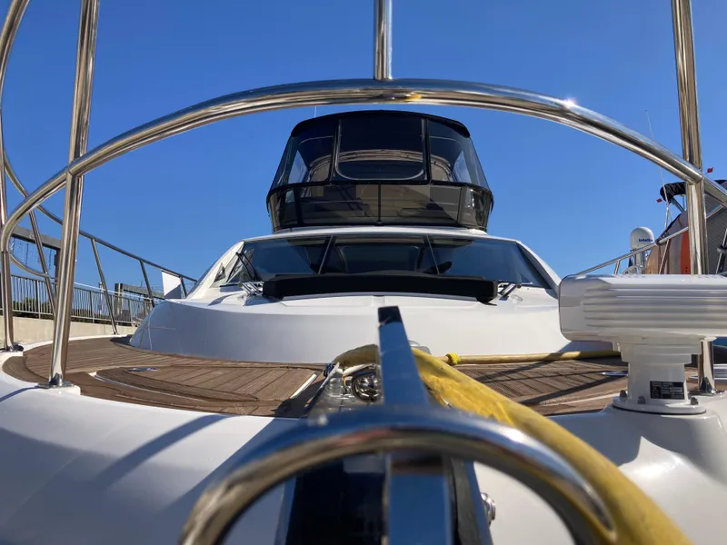 Slide: The Image of 2018 Sea Ray Fly 510 yacht, sleek design, docked under clear blue sky. - 11
