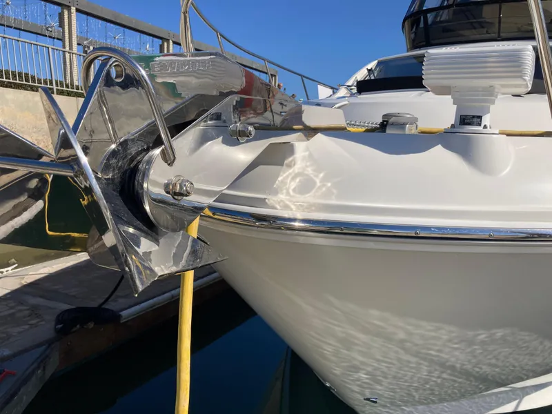 Slide: The Image of 2018 Sea Ray Fly 510 yacht bow with anchor, docked under clear blue sky. - 13