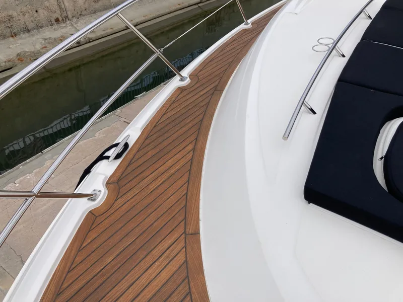 Slide: The Image of 2018 Sea Ray Fly 510 yacht deck with wooden flooring and railing. - 18